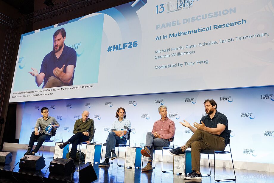 5 people sitting on a panel onstage.