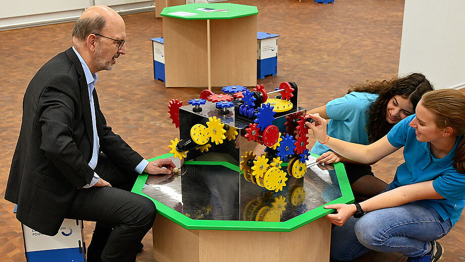 Three people interacting with exhibit.